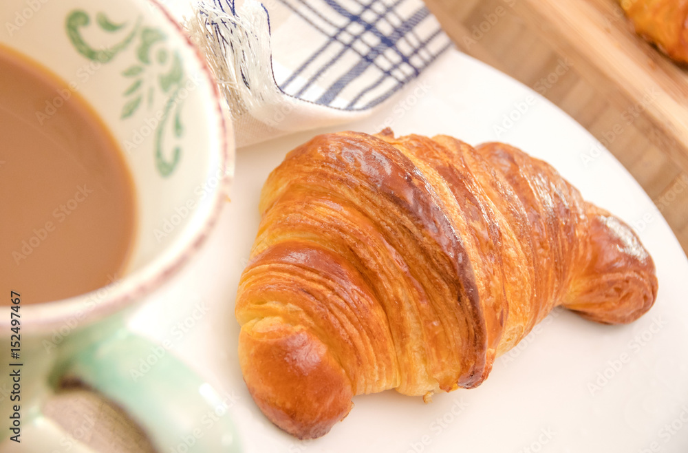 Fresh croissant and coffee for breakfast close up