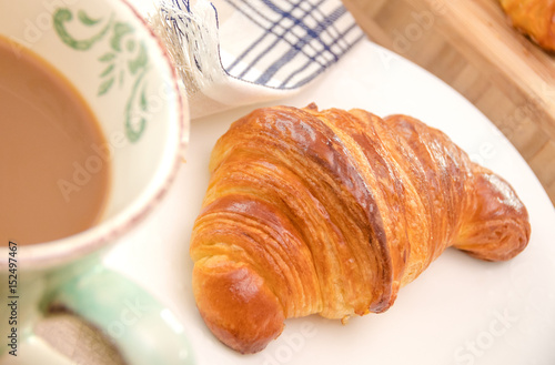 Fresh croissant and coffee for breakfast close up