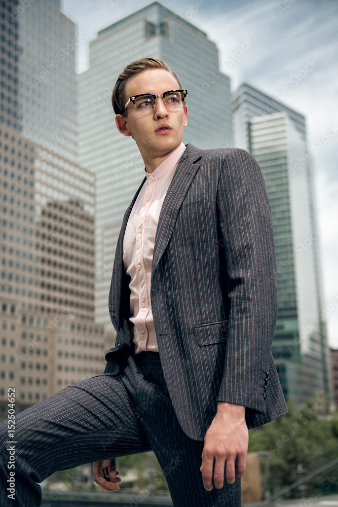 Handsome business men wearing suit and eyeglasses posing on city street Handsome business men wearing suit and eyeglasses posing on city street
