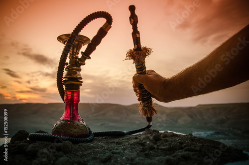 Hookah, traditional arabic waterpipe, direct sunset light, outdoor photo photo