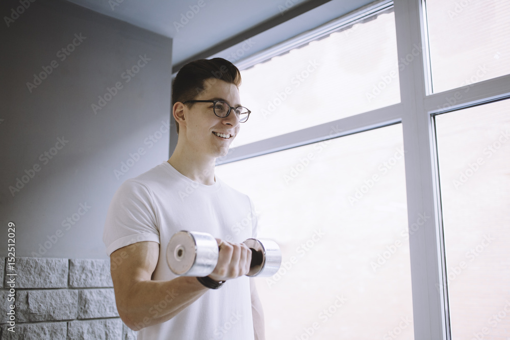 Young sportsman doing workout with dumbbell Young sportsman doing workout with dumbbell