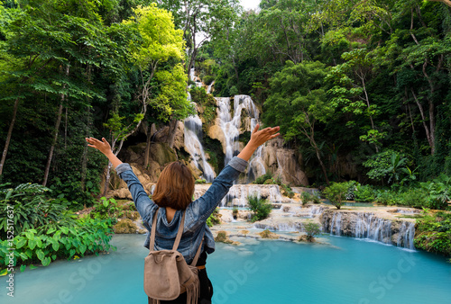 Women tourists wear jacket jeans at Tad Kwang Si Waterfall Land mark in Luang Prabang, Laos ,beautiful turquoise color water and Tropical forest  at Waterfall in north Lao photo