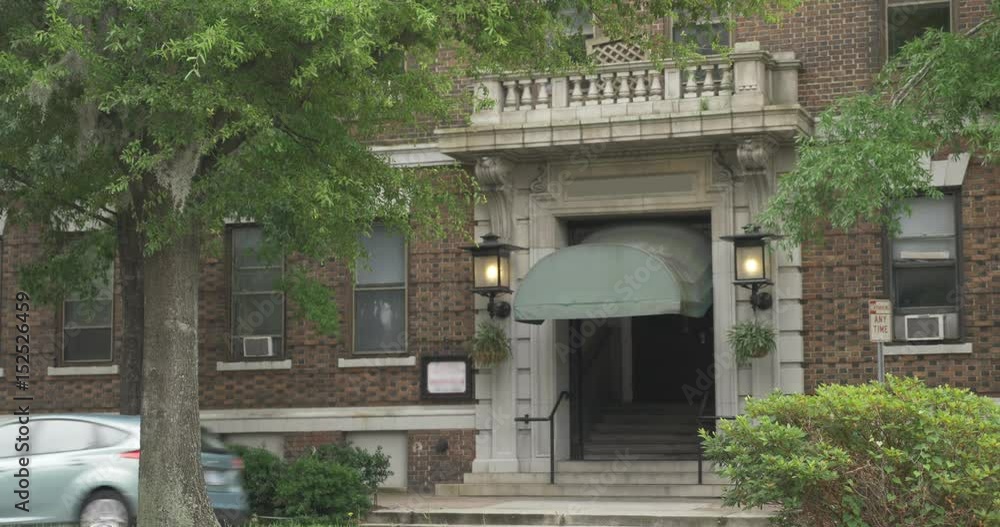 A daytime establishing shot of a typical Manhattan style apartment building entrance. A daytime establishing shot of a typical Manhattan style apartment building entrance.