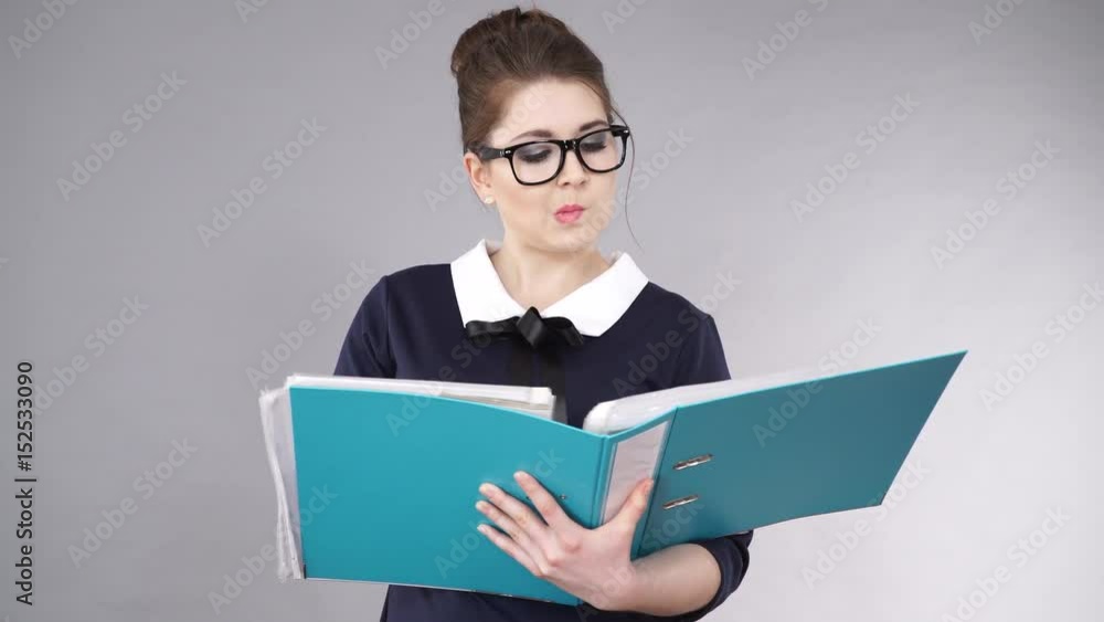Woman office worker agent holding blue file folder in hands. Young elegant businesswoman or secretary with documents bills. Thinking face expression. Business and paperwork on grey 4K ProRes HQ codec Woman office worker agent holding blue file folder in hands. Young elegant businesswoman or secretary with documents bills. Thinking face expression. Business and paperwork on grey 4K ProRes HQ codec