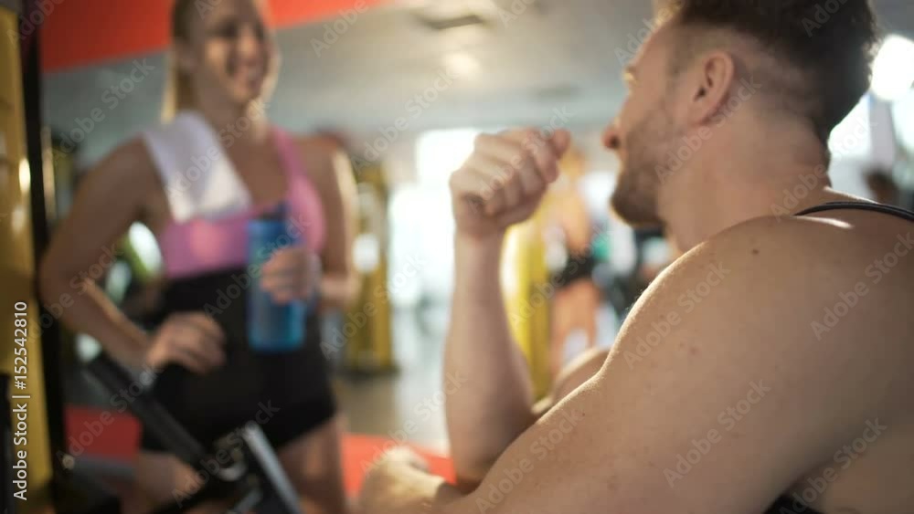 Attractive couple flirting after workout in gym, getting acquainted, hook-up Attractive couple flirting after workout in gym, getting acquainted, hook-up
