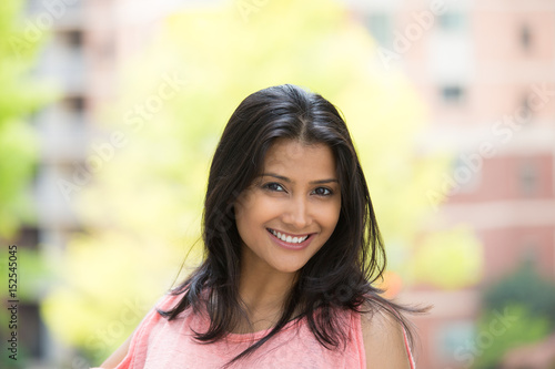 Closeup portrait of confident smiling happy pretty young woman in pink dress, isolated background of blurred trees, buildings. Positive human emotion facial expression feelings, attitude, perception Free Download Closeup portrait of confident smiling happy pretty young woman in pink dress, isolated background of blurred trees, buildings. Positive human emotion facial expression feelings, attitude, perception - GFXLoad