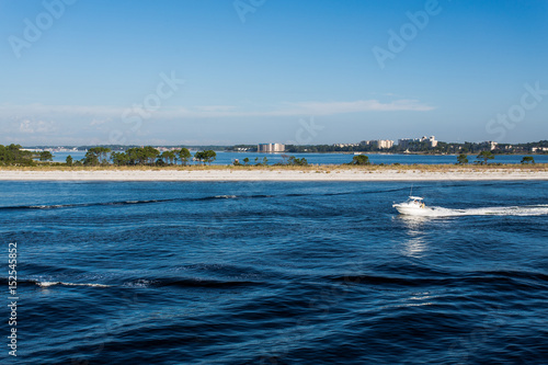 Power boat crossing in front of sandy beach