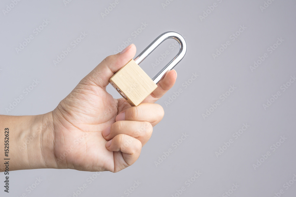 Hand holding metal padlock