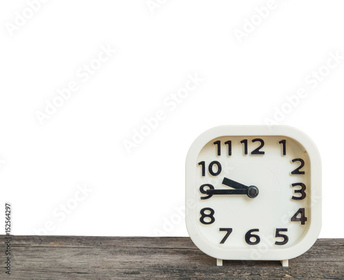 Closeup white clock for decorate show a quarter to ten o'clock or 9:45 a.m. on old brown wood desk isolated on white background with copy space