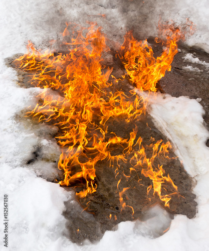 fiery flame on the white snow in winter © schankz