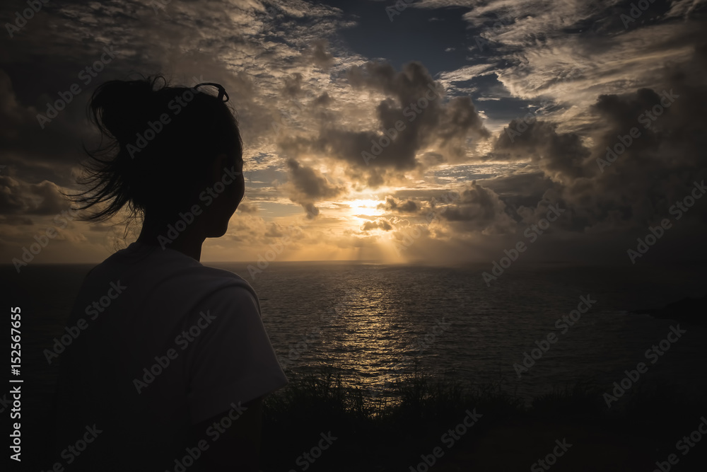 A gril looking Sunset sky over sea at Promthep Cape, phuket city