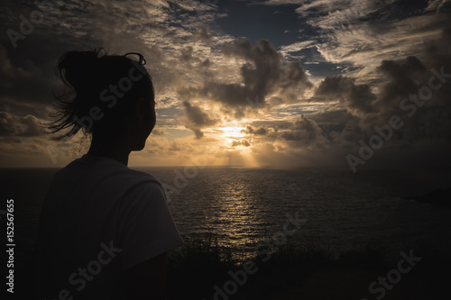 A gril looking Sunset sky over sea at Promthep Cape, phuket city © Jirapong