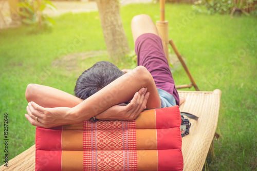 Rear view of man relaxing on chair at home with thailand style