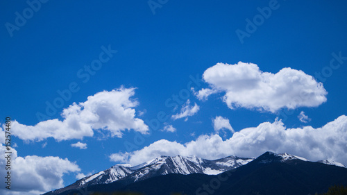 Photo depicting a beautiful moody frosty landscape. European alpine mountains with snow peaks on a blue sky background.