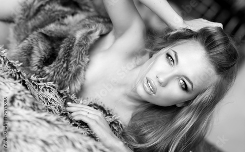 Fotografie beautiful woman in lingerie lying on bearskin