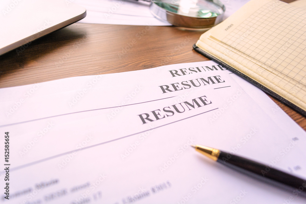 Resume, pen, magnifier, laptop on your desktop. job search Resume, pen, magnifier, laptop on your desktop. job search