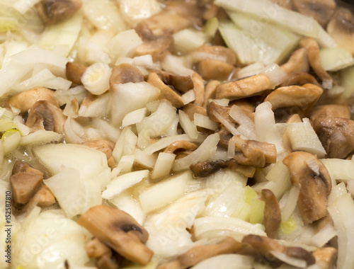 Mushrooms with onions are fried in a frying pan