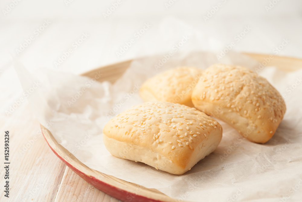 Cooked buns with sesame seeds on the baking paper Cooked buns with sesame seeds on the baking paper