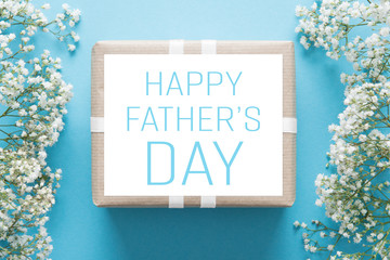 Father's day background, blue background with white flowers and a present