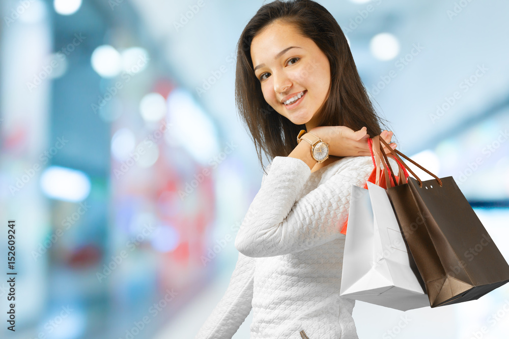 Happy young woman holding many shopping bags