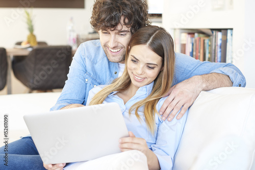 Relaxed young couple. Shot of a happy young couple relaxing at home and using a laptop.