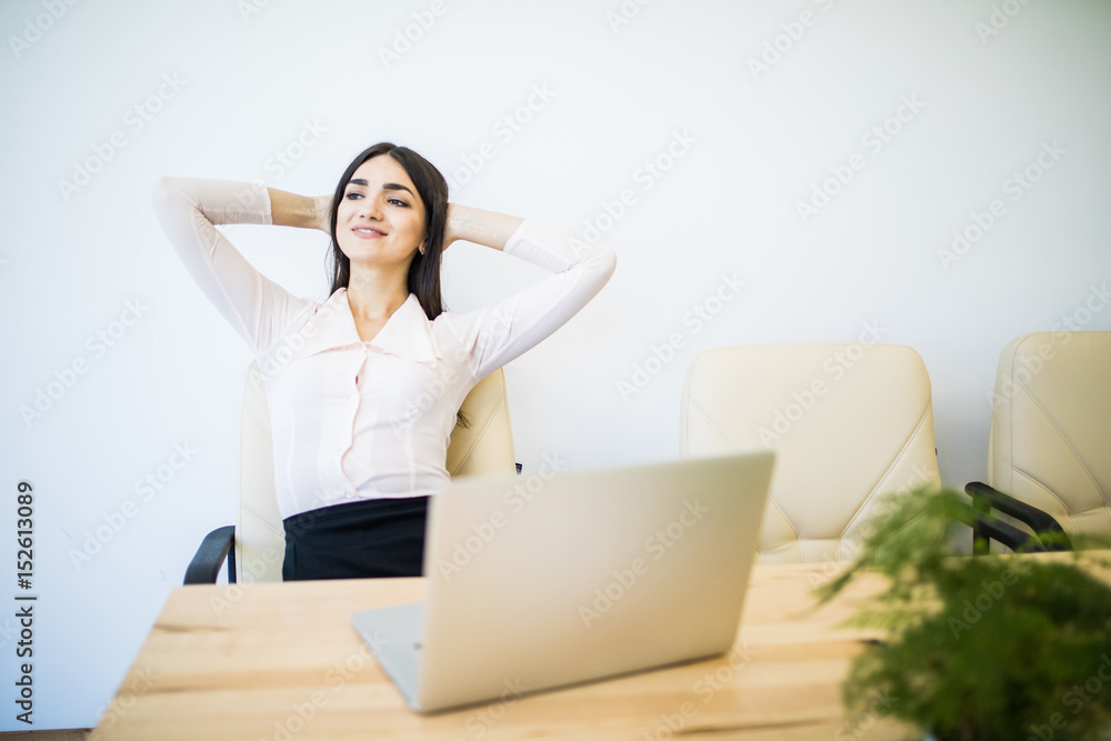 Business woman relaxing with hands behind her head and sitting on an office chair Business woman relaxing with hands behind her head and sitting on an office chair