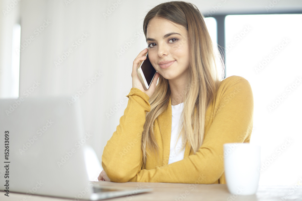 Home office. Shot of a beautiful young woman using laptop and talking with somebody while working at home. Home office. Shot of a beautiful young woman using laptop and talking with somebody while working at home.