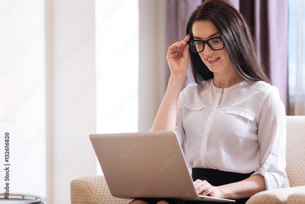 Attractive intelligent businesswoman fixing her glasses Attractive intelligent businesswoman fixing her glasses