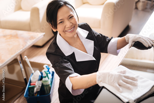 Cheerful positive woman cleaning the hotel room