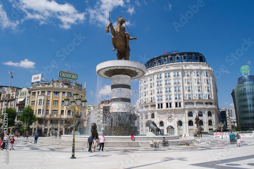 Unidentified people pass the fountain monument to Alexander the Great in Macedonia Square, Skopje, Republic of Macedonia