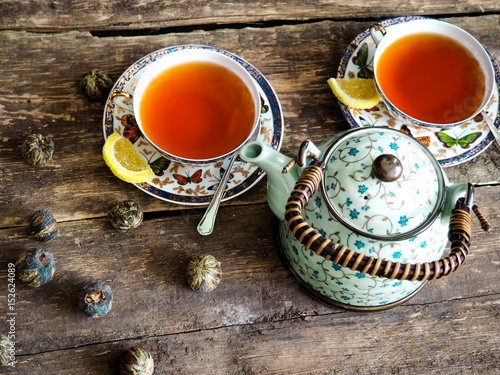 Teapot and glass cups with tea against wooden background