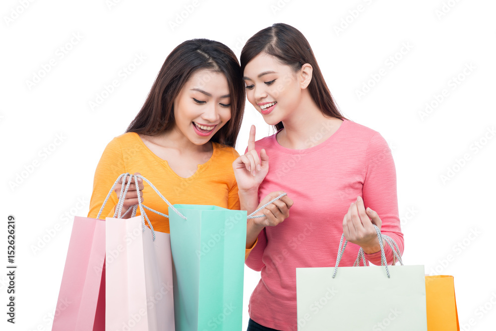 Two asian girl friends with shopping isolated on white Two asian girl friends with shopping isolated on white