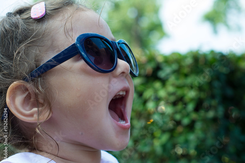 Summer. Little emotional girl in large sunglasses.   © disha1980
