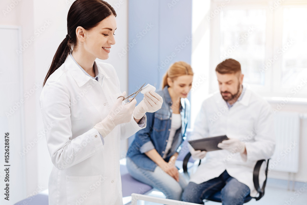 Fototapeta premium Joyful pleasant woman assisting in the doctors office