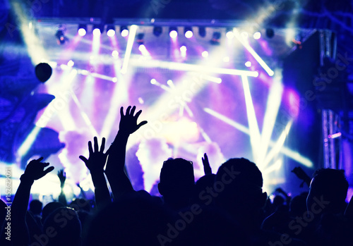 Crowd at a music concert, audience raising hands up