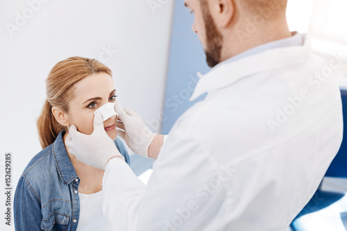 Pleasant pretty woman looking at her doctor