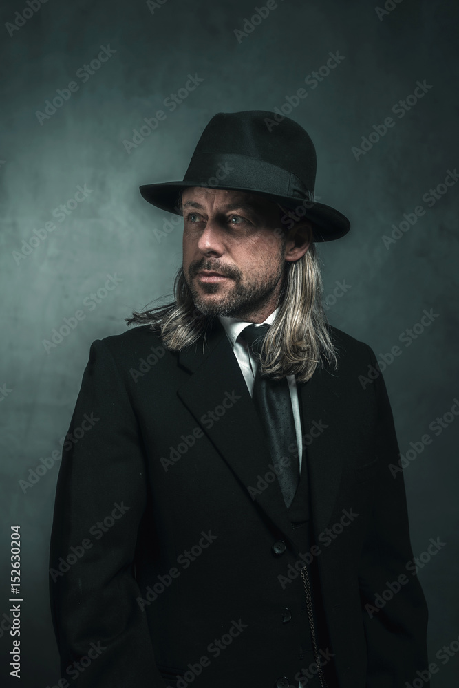Retro victorian style man with blond long hair and hat. Wearing black suit  and tie. Stock Photo | Adobe Stock