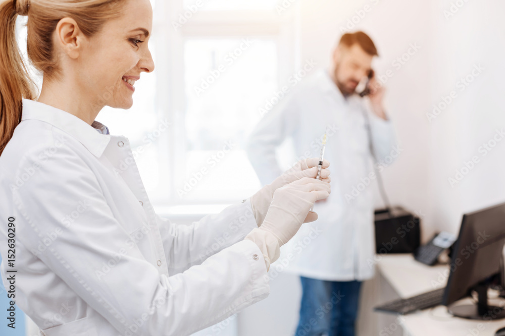 Happy delighted doctor preparing for injection Happy delighted doctor preparing for injection