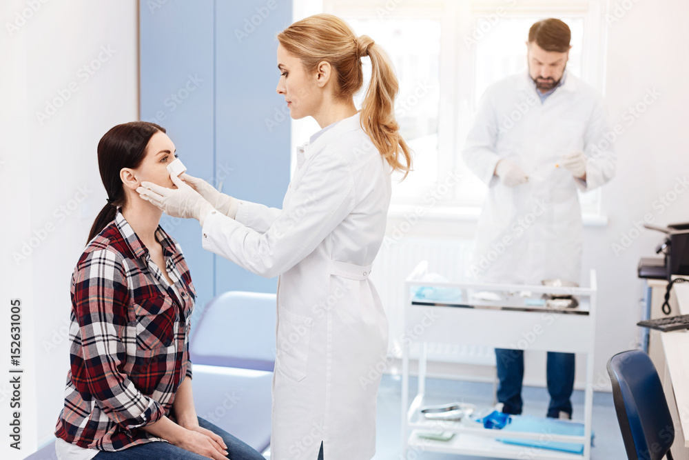 Fototapeta premium Experienced cosmetic surgeon looking at her patient