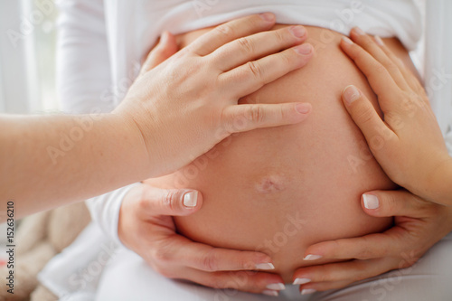 Tableau sur toile Several hands touch the belly of a pregnant woman