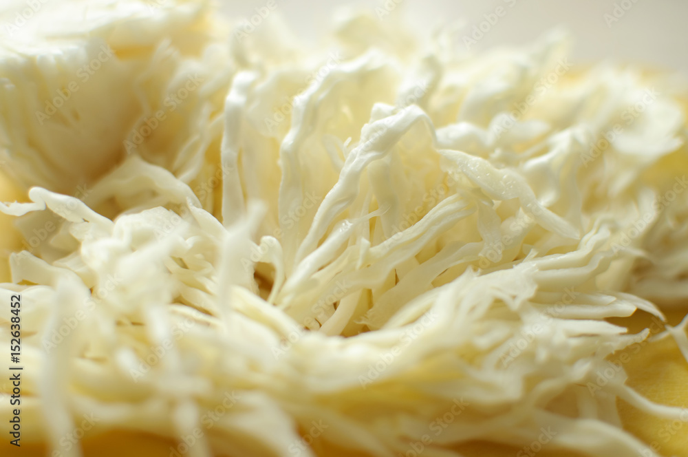 Sliced white cabbage on a yellow cutting board