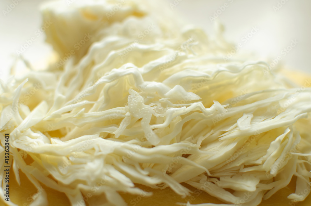 Sliced white cabbage on a yellow cutting board Sliced white cabbage on a yellow cutting board