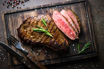 Fototapete Steakhouse Gegrilltes Steak auf Holzbrett  © nadianb