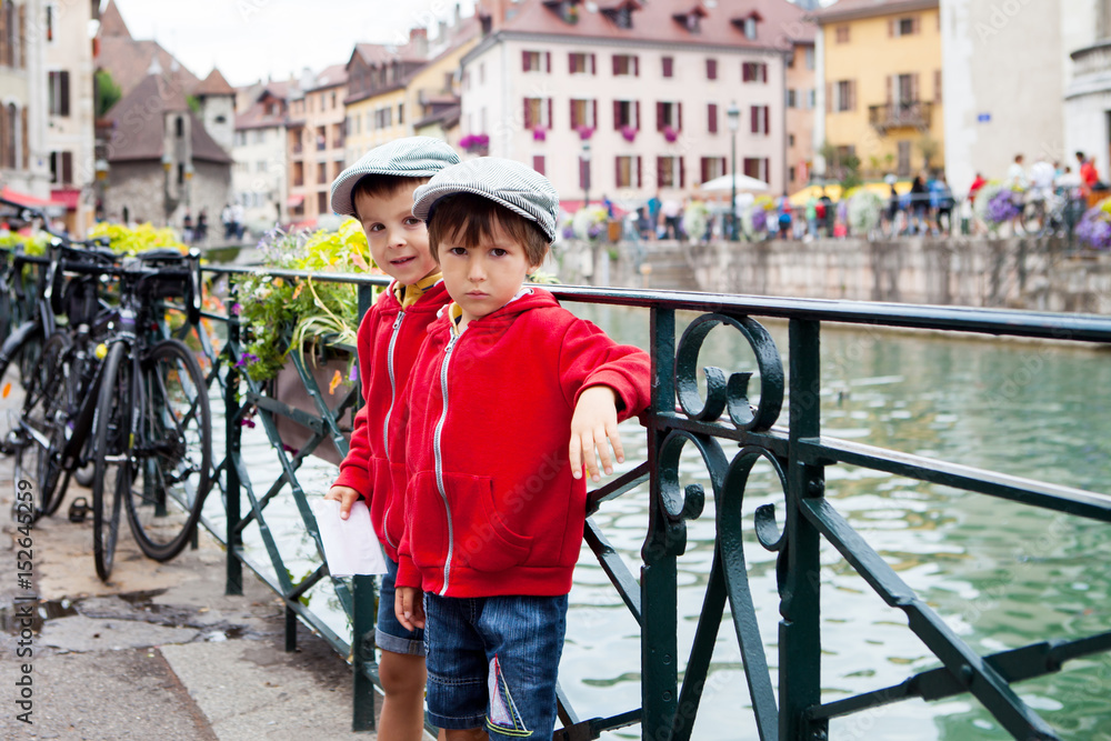 Φωτογραφία Portrait of two boys, brothers, in the town of Annecy, next to a channe