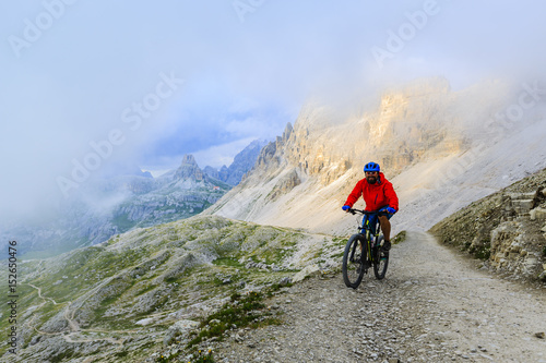 View of cyclist riding mountain bike on trail in Dolomites,Tre Cime di Laverado, South Tirol, Italy