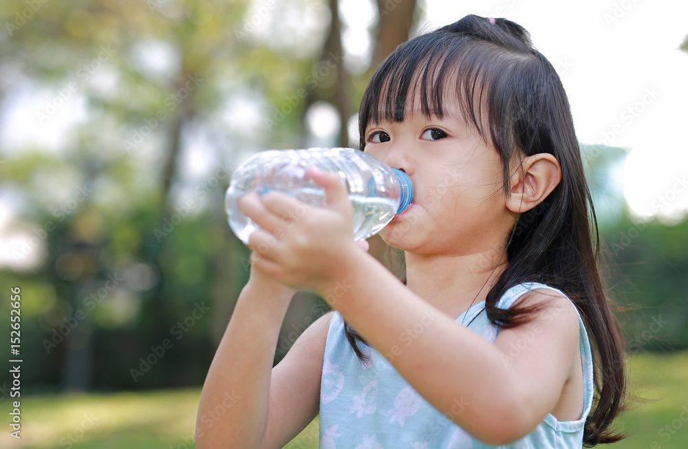 Close Up little girl drinking water from bottle in the park. Portrait outdoor. Close Up little girl drinking water from bottle in the park. Portrait outdoor.