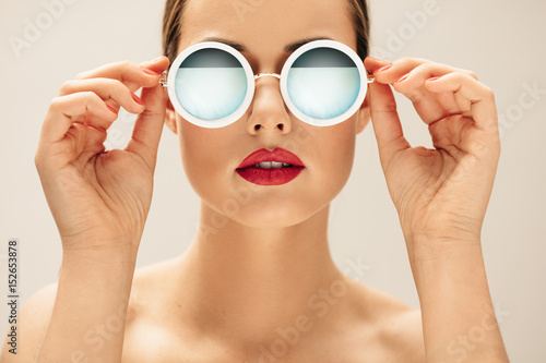 Young woman in sunglasses and red lips photo