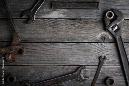 Dirty set of hand tools on a wooden background Old rusty Equipment for locksmith and metalworking shop Old shop Old working tools. Vintage working tools drill saw ruler and others on wooden background