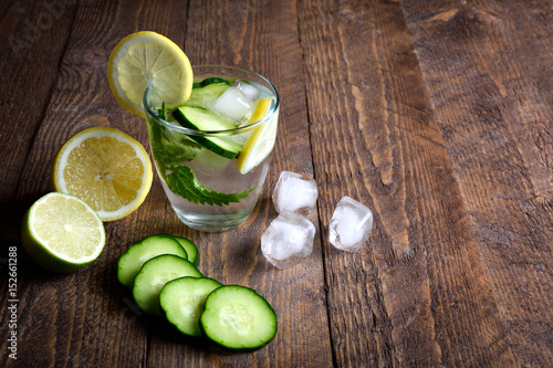 Water with lemon,lime  mint and cucumber on the wooden dark background. Water Detox.on wooden background