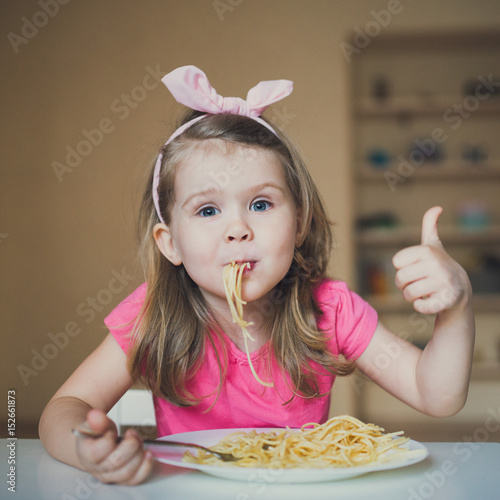 cute girl eating pasta and thumb